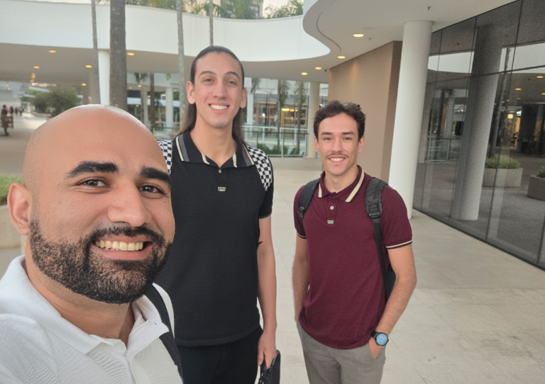 Professor e dois alunos em visita técnica a um centro empresarial