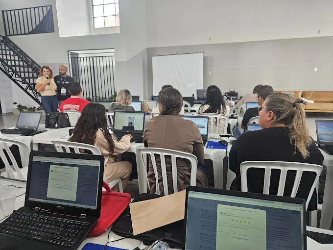 Sala ampla com participantes praticando em notebooks durante treinamento